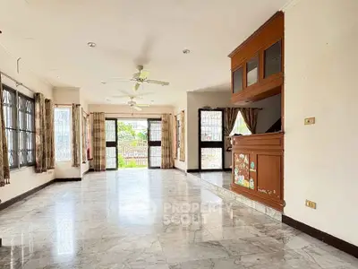 Spacious living room with marble floors and large windows for natural light.