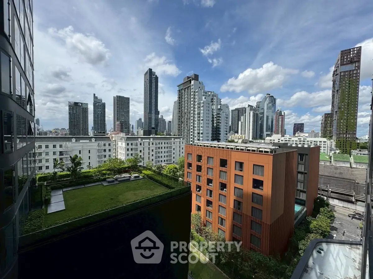 Stunning cityscape view from a high-rise building with lush green rooftop garden.