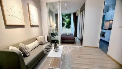 Modern living room with cozy sofa and stylish decor leading to a bedroom with a balcony view.