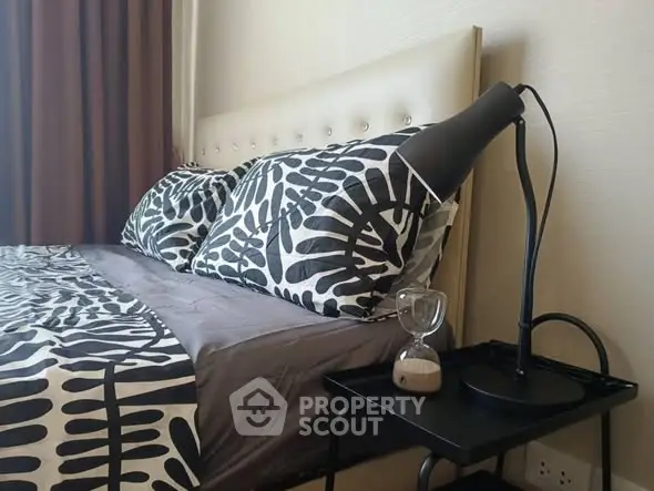 Modern bedroom with stylish bedding and sleek bedside lamp