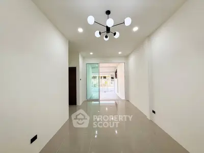 Spacious modern living room with elegant lighting and glossy tiled floors.