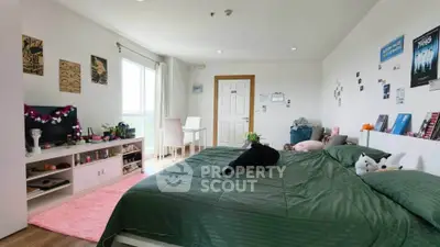 Spacious bedroom with modern decor and large window offering natural light.