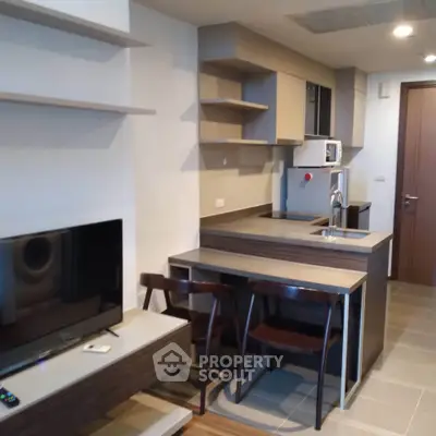 Modern kitchen with sleek design and open layout, featuring a compact dining area and stylish cabinetry.
