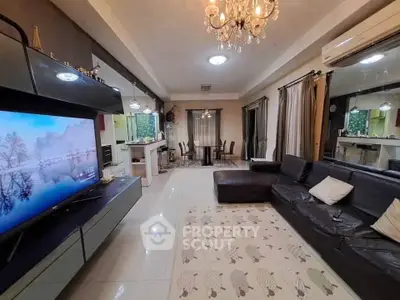 Spacious living room with modern decor and open layout, featuring a large sectional sofa and elegant chandelier.