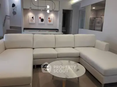 Modern living room with stylish white sectional sofa and marble coffee table