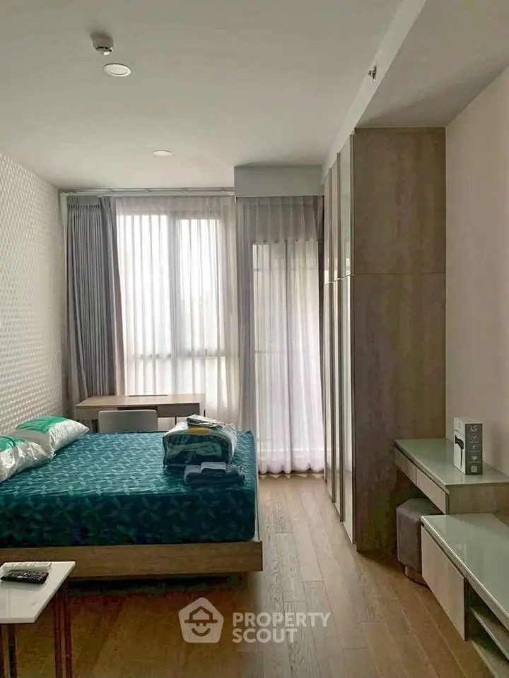Modern bedroom with stylish decor and natural light, featuring a comfortable bed and sleek furniture.