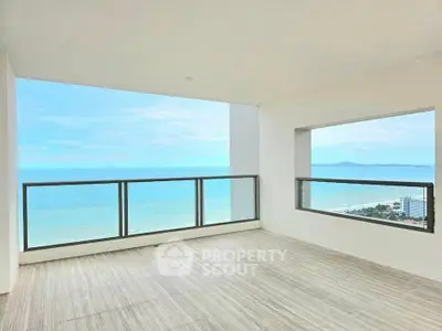 Stunning ocean view from spacious balcony in modern high-rise apartment.