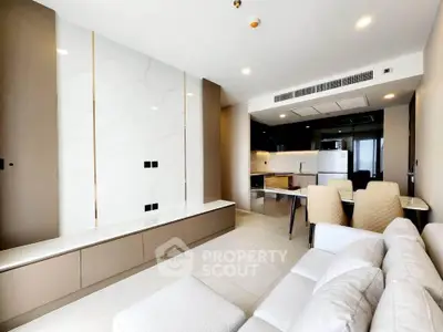 Modern living room with open kitchen, sleek design, and elegant furnishings in a contemporary apartment.