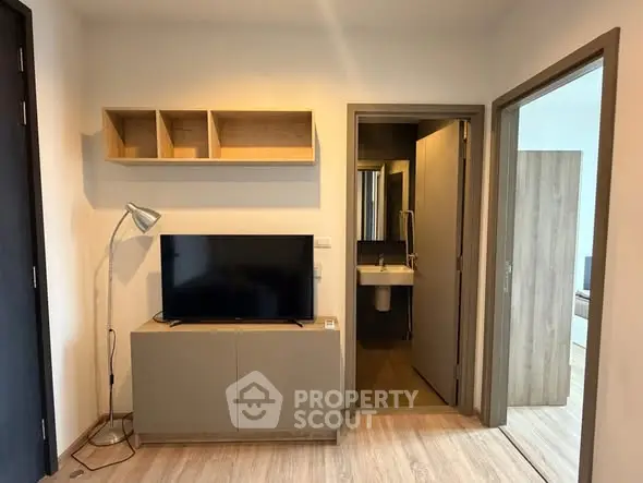 Modern living room with TV and stylish shelving in a cozy apartment.