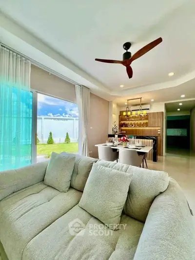 Spacious living room with modern decor and open kitchen layout, perfect for entertaining.