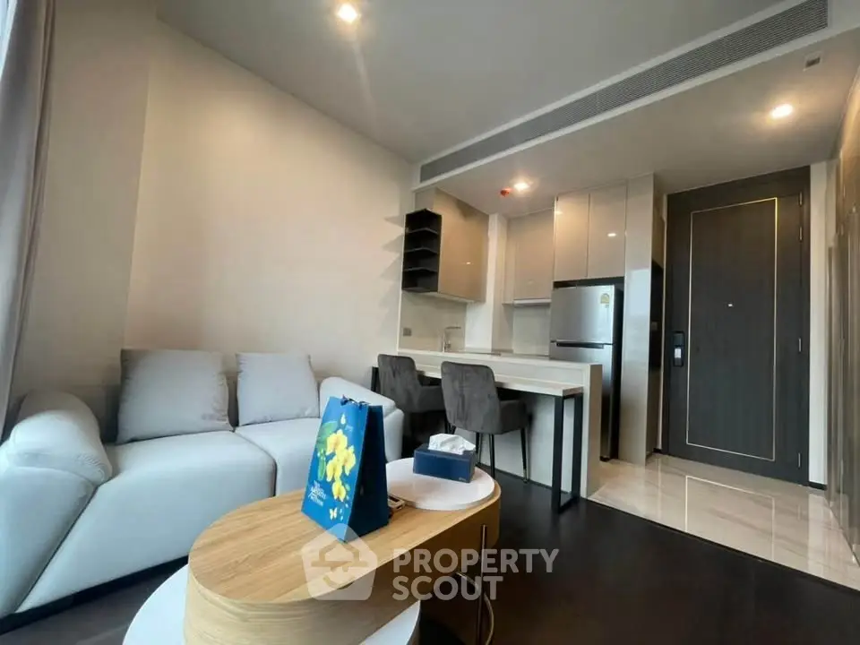 Modern living room with sleek kitchen and stylish furniture in open layout apartment.