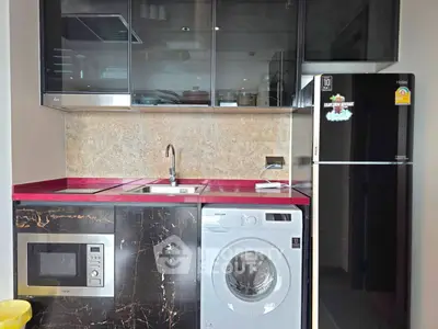 Modern kitchen with sleek appliances and red countertop