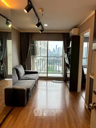 Modern living room with city view, wooden flooring, and cozy sofa in a high-rise apartment.