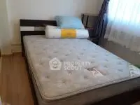 Cozy bedroom with a large comfortable bed and natural light filtering through the window, perfect for restful nights in a serene home environment.