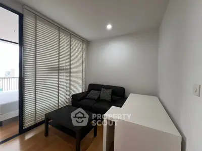 Modern living room with sleek furniture and balcony view in urban apartment.