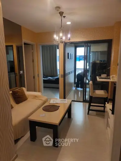 Modern living room with elegant chandelier and cozy seating area in stylish apartment.