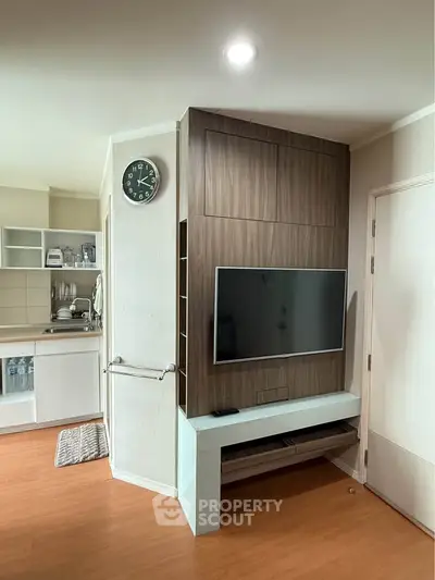 Modern living room with sleek TV unit and compact kitchen area