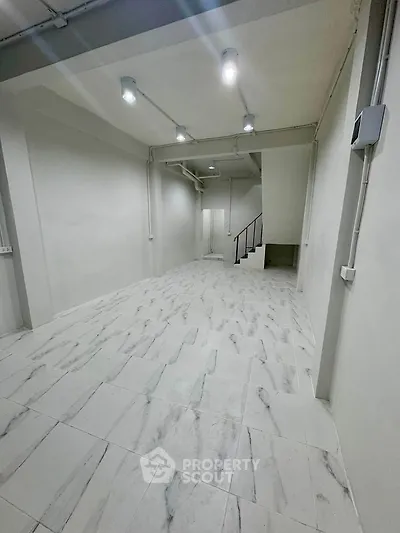 Spacious modern interior with sleek lighting and marble flooring, ideal for versatile use.