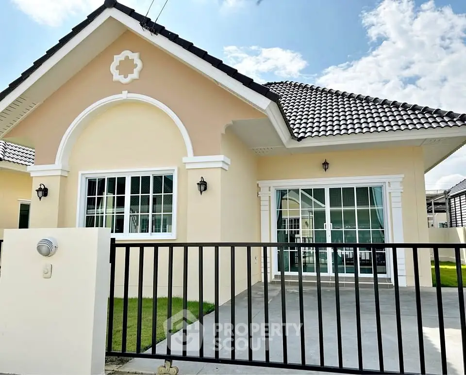 Charming single-story home with tiled roof and spacious front patio.