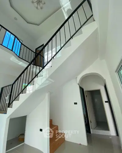 Modern two-story interior with sleek staircase and high ceiling