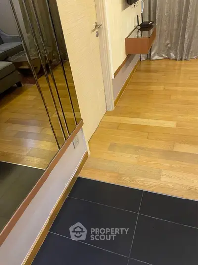 Modern interior with wooden flooring and mirrored wall in a stylish living space.