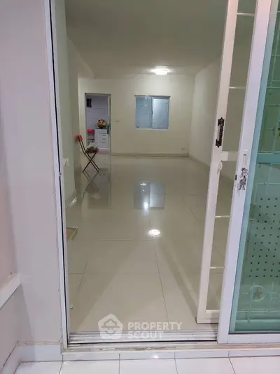 Spacious empty room with glossy tiled floor and sliding glass doors