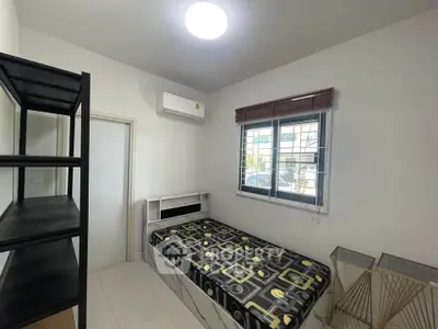 Cozy bedroom with single bed, air conditioning, and modern shelving in a bright, minimalist design.