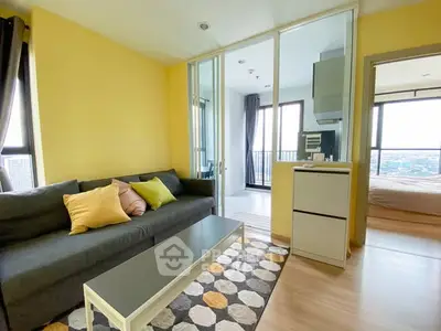 Modern living room with vibrant yellow walls and cozy furnishings in a high-rise apartment.
