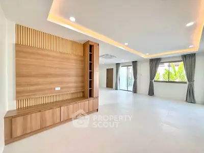 Spacious modern living room with elegant wood paneling and large windows for natural light.