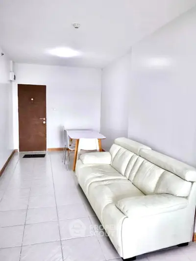 Modern living room with white sofa and dining table in a bright apartment.
