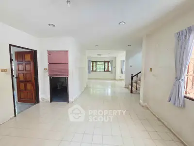 Spacious open-plan living area with tiled flooring and natural light