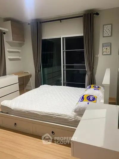 Modern bedroom with stylish furniture and large window, perfect for cozy living.
