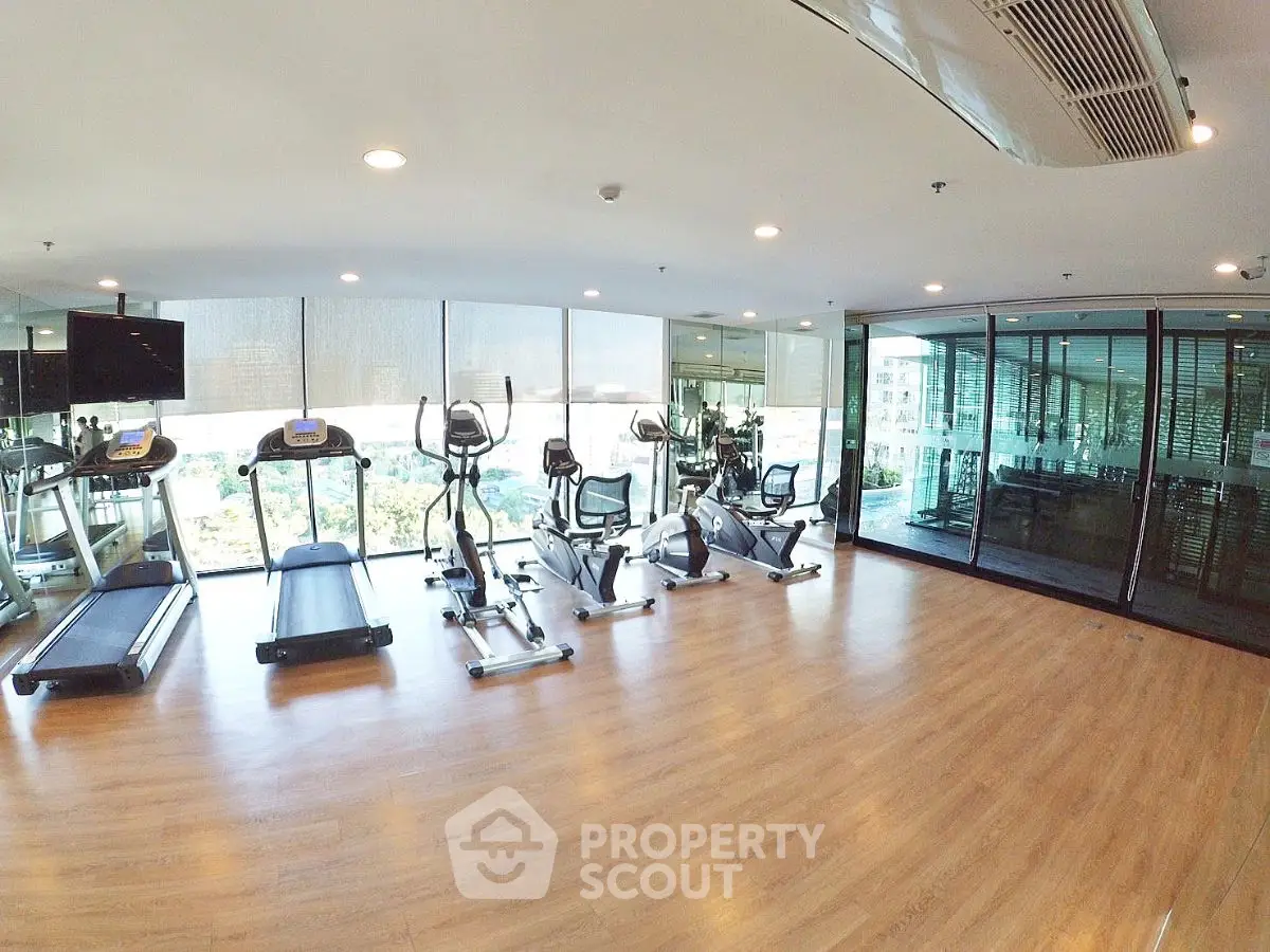 Spacious modern gym with exercise equipment and large windows