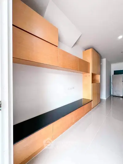 Modern kitchen with sleek wooden cabinetry and glossy floor tiles