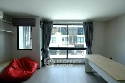 Spacious modern living room with large window and stylish decor