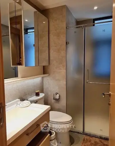 Modern bathroom with glass shower and elegant vanity in a stylish apartment.