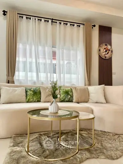 Elegant living room with plush sofa, stylish coffee tables, and chic decor.