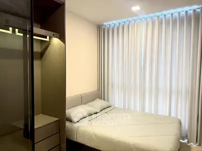 Cozy bedroom with modern design and ample natural light from large windows.