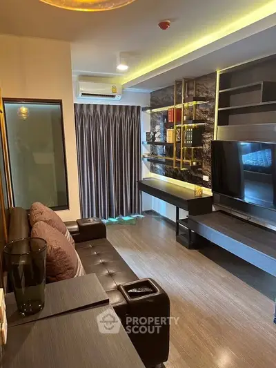 Modern living room with sleek design, large TV, and stylish shelving.