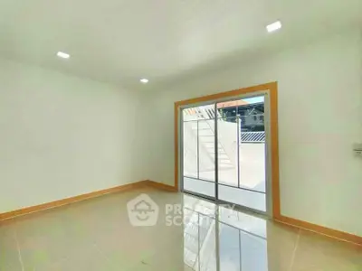 Spacious room with sliding glass doors leading to a bright outdoor area, perfect for natural light lovers.
