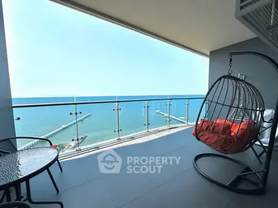Stunning balcony with panoramic ocean view and cozy seating area.