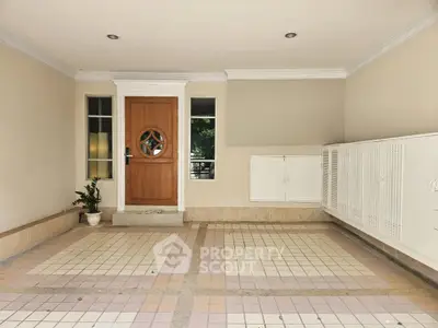 Spacious tiled entrance with wooden door and storage cabinets, ideal for welcoming guests.
