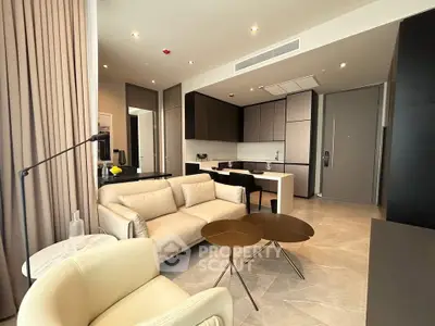 Modern open-layout living room with sleek kitchen and stylish furniture in luxury apartment.