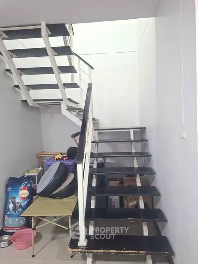 Modern staircase in a residential property with storage space underneath, showcasing sleek design and functionality.