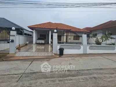 Charming single-story home with red-tiled roof and spacious driveway in a serene neighborhood.