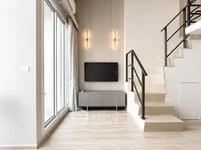 Modern living room with sleek staircase and large windows, perfect for natural light lovers.