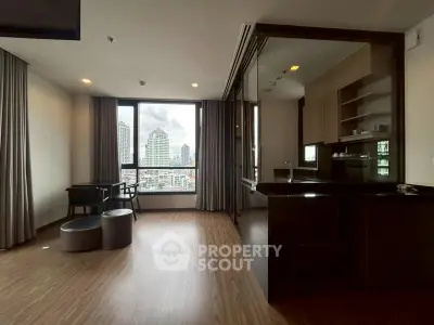 Modern open-layout living space with city view and sleek kitchen design.