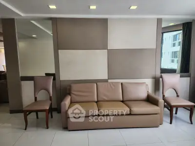 Modern living room with stylish beige sofa and elegant chairs, perfect for relaxation and entertaining.