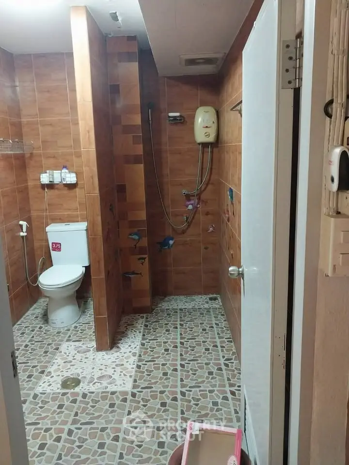 Spacious bathroom with modern shower and tiled walls, ideal for comfort and relaxation.
