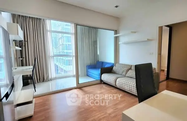 Modern living room with wooden flooring and large windows in a high-rise apartment.